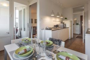 a dining room with a table with green plates on it at Modern Apartment near Faculty of El Engineering in Zagreb