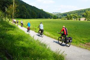um grupo de pessoas andando de bicicleta por uma estrada em Ferienwohnung Tielmann em Felsberg