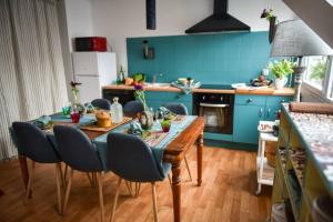 a kitchen with a wooden table and blue walls at Duplex tout équipé, proche centre-ville COLMAR, parking in Colmar