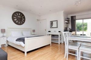 1 dormitorio con 1 cama y reloj en la pared en Self-contained Apartment, en Corsham