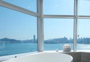 a bathroom with a tub and a large window at H Avenue Gwanganri Beach in Busan