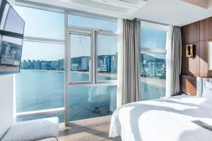 a bedroom with a large window with a view of the water at H Avenue Gwanganri Beach in Busan