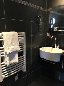 La salle de bains est pourvue d'un lavabo et d'un sèche-serviettes. dans l'établissement Le Manoir d'à Côté, à Courseulles-sur-Mer 129 autres photos