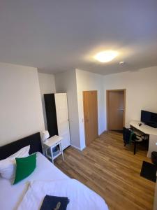 a bedroom with a bed and a desk in it at Pension No.9 in Parchim +23 photos