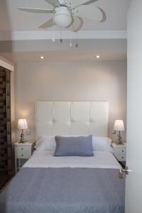 1 dormitorio con 1 cama blanca grande y ventilador de techo en Casa Danesa, en Marbella