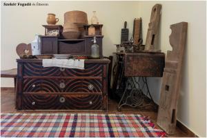 una habitación con un tocador de madera con muchos artículos. en Szekér Fogadó, en Bátonyterenye