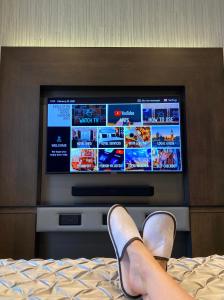 a person laying on a bed with a tv at Eccleston Square Hotel in London