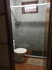 La salle de bains est pourvue de toilettes et d'une porte de douche en verre. dans l'établissement Casa Sossego da Montanha, à Visconde de Mauá 40 autres photos