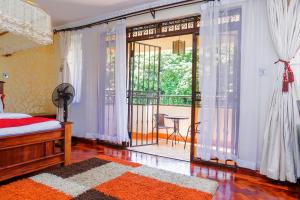 a bedroom with a bed and a large window with a balcony at Orchid Homes, Gigiri in Nairobi