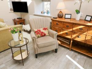 a living room with a chair and a table at Lottie's Loft in Grassington