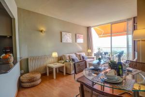 uma sala de estar com uma mesa e um sofá em La Gioia 3 by Hello Homes Sitges em Sitges