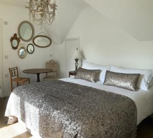 a bedroom with a bed and a table and mirrors at Harford en-suite Rooms in Lymington