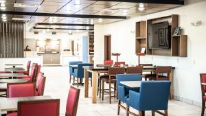 a restaurant with tables and chairs and a flat screen tv at Holiday Inn Express Hotel & Suites Sedalia, an IHG Hotel in Sedalia