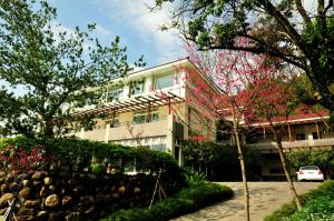 a building with a car parked in front of it at Zen and Pine Resort in Shuili