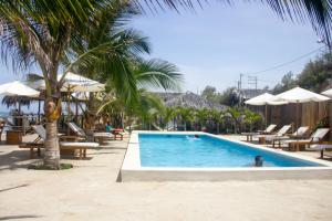 a pool at a resort with people swimming in it at Baja Canoas Hotel in Canoas de Punta Sal