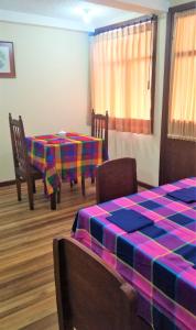 a room with two tables and chairs with a colorful table cloth at LA CASA DEL CENTRO in Quito