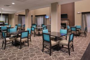 a dining room with tables and chairs and a fireplace at Holiday Inn Express & Suites Bakersfield Airport, an IHG Hotel in Bakersfield