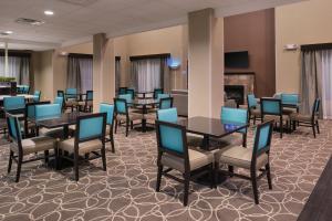 a dining room with tables and chairs and a fireplace at Holiday Inn Express & Suites Bakersfield Airport by IHG in Bakersfield