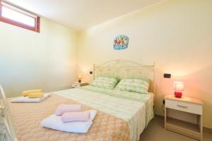 een slaapkamer met een bed met 2 kussens erop bij New Apartment Leuca in Leuca
