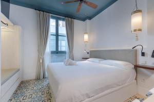 Un dormitorio con una gran cama blanca y una ventana en Apartamentos Caminante del Agua en Sevilla