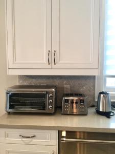 a kitchen counter with a microwave and a toaster oven at Comfortable private space in Pickering