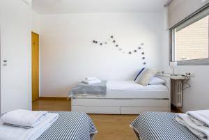 een slaapkamer met 2 bedden en een raam bij Lodging Apartments Beach Apartment Villa Olimpica in Barcelona