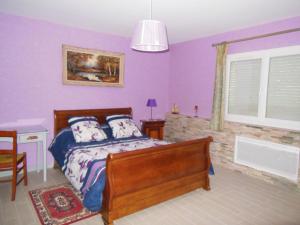 a bedroom with purple walls and a bed and a window at LES BRUYERES in Chaptelat