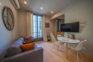 sala de estar con sofá y mesa en Bonavista Apartments - Eixample, en Barcelona