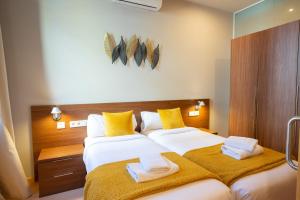 sypialnia z 2 łóżkami i żółtymi i białymi ręcznikami w obiekcie Bonavista Apartments - Eixample w Barcelonie