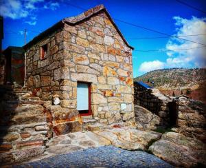 a stone building with a window on the side of it at Casa da Avó Ana Alvão in Bilhó