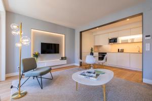 a living room with a table and chairs and a kitchen at Ando Living - São Nicolau Townhouse in Lisbon