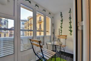 a small balcony with a glass table and a chair at Residenza Napoli Centrale in Naples