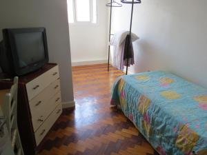 1 dormitorio con cama y vestidor con TV en City Hotel, en Caxias do Sul