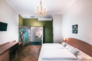 een kamer met 3 bedden en een kroonluchter bij BoutiqueHOTEL Donauwalzer in Wenen