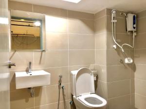 a bathroom with a toilet and a sink and a shower at Escapade Prison Suites Petaling Jaya in Petaling Jaya