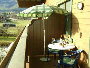 a table and chairs with an umbrella on a porch at Ferienwohnung Fred in Hollersbach im Pinzgau +6 photos