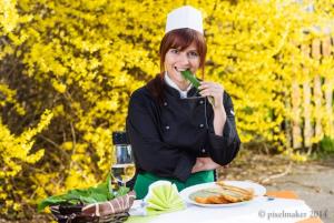 a woman sitting at a table in a chefs hat eating food at Gasthof Zum Lindenhof in Bad Radkersburg