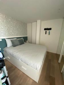 Dormitorio pequeño con cama blanca con cruces en la pared en hill4 en Ostende