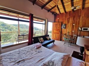 a bedroom with a large bed and a large window at Apartment Monte Luna Mountain View in Monteverde Costa Rica