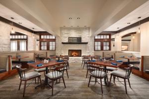 a restaurant with tables and chairs and a fireplace at Holiday Inn Houston Intercontinental Airport by IHG in Houston