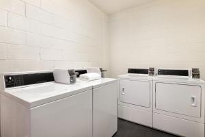 a white laundry room with two washes and a sink at Holiday Inn Houston Intercontinental Airport by IHG in Houston