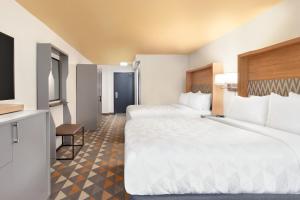 a hotel room with two beds and a television at Holiday Inn Houston Intercontinental Airport by IHG in Houston