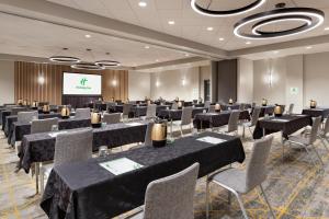 a conference room with tables and chairs and a screen at Holiday Inn Houston Intercontinental Airport by IHG in Houston