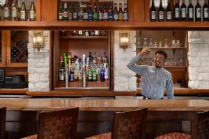 a man standing behind a bar in a bar at Holiday Inn Houston Intercontinental Airport by IHG in Houston