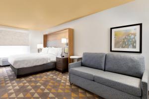 a hotel room with a bed and a couch at Holiday Inn Houston Intercontinental Airport by IHG in Houston