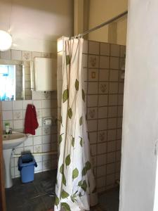a bathroom with a shower curtain with leaves on it at Tranquility in Klein Karoo in Oudtshoorn