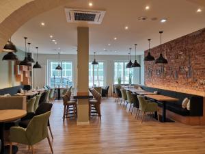 a restaurant with tables and chairs and a brick wall at Hotel Westfalia in Bremen