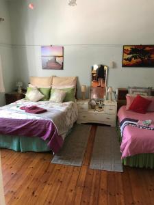 a bedroom with two beds and a mirror at Tranquility in Klein Karoo in Oudtshoorn