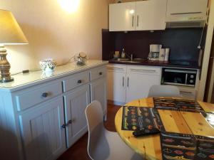 a kitchen with white cabinets and a table with chairs at lanton in Lanton