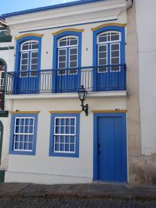 a house with a blue door and a balcony at Suite Família Inconfidentes in Ouro Preto